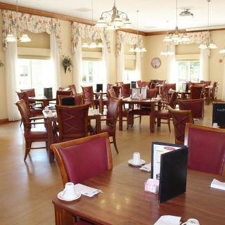 An elegant dining room with neatly arranged tables and chairs, featuring tasteful decor and ample lighting.