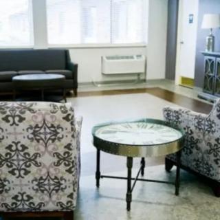 A modern office lobby featuring patterned chairs and a round table.