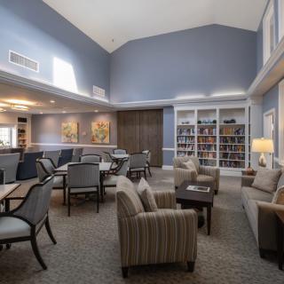 A spacious living room with comfortable seating and a library section.