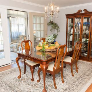 Elegant dining room with wooden furniture and chandelier.