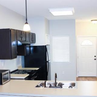 A modern kitchen interior with dark cabinets and appliances.