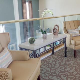 A cozy living room setup featuring beige chairs and a decorative coffee table adorned with plants.