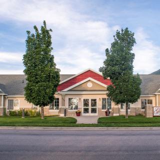 A front view of a building with trees and a clear sky.