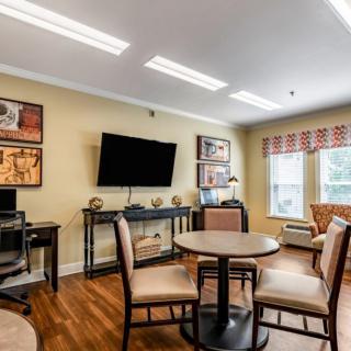 A cozy and modern living room with a television, seating area, and computer desk.