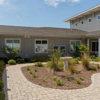 A modern single-story house with landscaped garden and patio area.