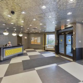 Modern lobby area with a reception desk and entrance doors.