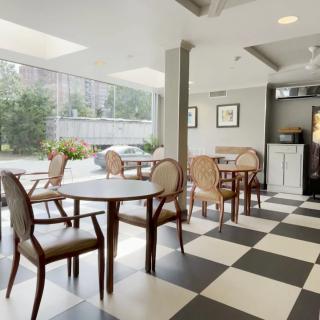 A modern cafe interior with checkered flooring and large windows allowing natural light to fill the space.