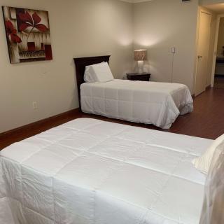 A neatly arranged bedroom with two single beds and a nightstand between them.