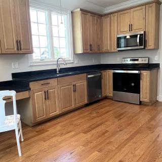 A modern kitchen with wood cabinets and stainless steel appliances.