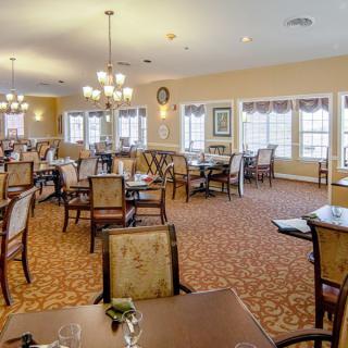 A spacious and well-lit dining area with neatly arranged tables and chairs.