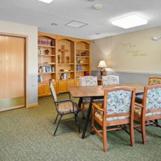 A well-lit meeting room with a conference table, several chairs, and built-in bookshelves.