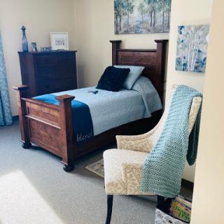 A cozy and inviting bedroom featuring a wooden bed, comfortable chair, and tasteful decor.