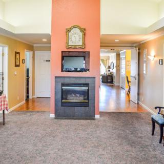 A cozy living room with a central fireplace and decorative clock.