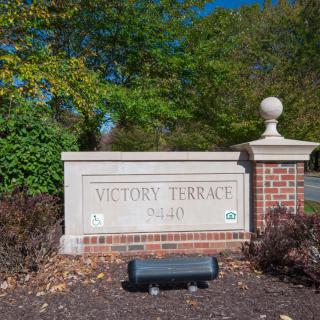 Entrance sign for Victory Terrace surrounded by trees.