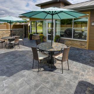 A sunny outdoor patio with tables and chairs under umbrellas.