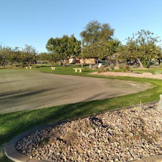 A scenic view of a golf course, showcasing well-maintained greens and surrounding trees.