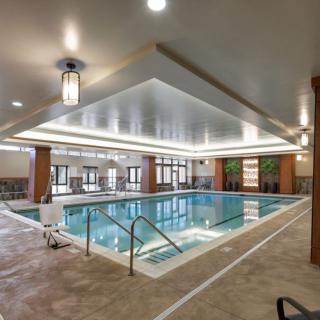 A luxurious indoor swimming pool with ample lighting and elegant decor.