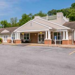 A motel entrance with a parking lot on a clear day.