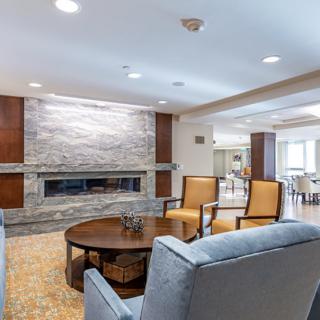 A modern living room with comfortable seating and a sleek fireplace.