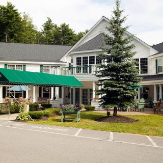 A charming residential building with a well-maintained garden and driveway.