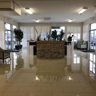 A modern and spacious lobby area with sleek furniture and plants.