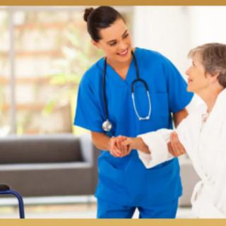 A nurse in blue scrubs assists an elderly patient with a walker.