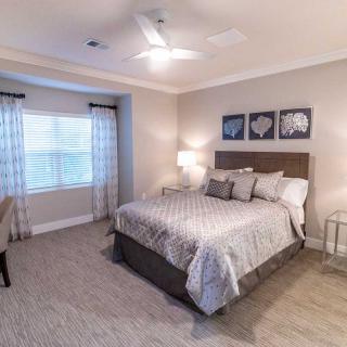 A modern bedroom with a large bed, soft lighting, and stylish decor.