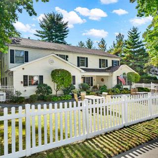A suburban house with a white picket fence and garden.