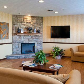 A cozy living room with comfortable seating, a stone fireplace, and modern decor.