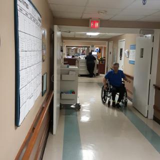A patient navigating a hospital corridor in a wheelchair.