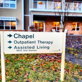 A directional sign indicating the locations of the chapel, outpatient therapy, and assisted living services.
