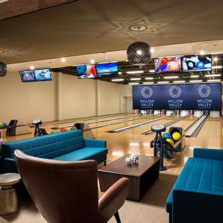 A modern bowling alley with multiple lanes and a comfortable seating area.