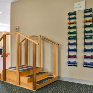 A physical therapy room with stairs and dumbbells for rehabilitation exercises.