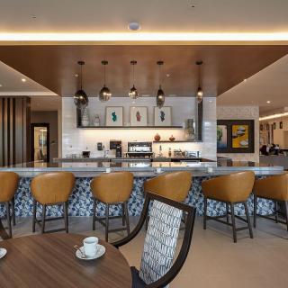 A modern bar area with stylish chairs and coffee cups on the counter.