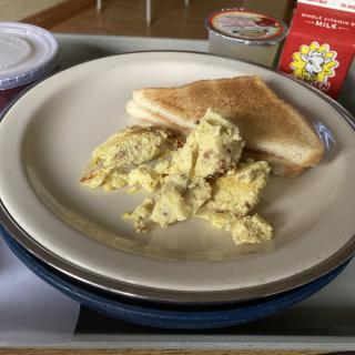 A plate of scrambled eggs served with toast.