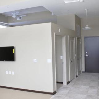 A modern apartment interior with a mounted television and multiple doorways.