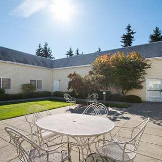 A sunny courtyard with outdoor seating and landscaped greenery.