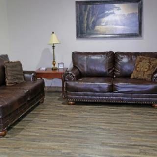 A cozy living room with leather sofas and a warm ambiance.