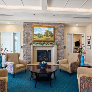 A cozy living room with a fireplace, comfortable seating, and decorative artwork.
