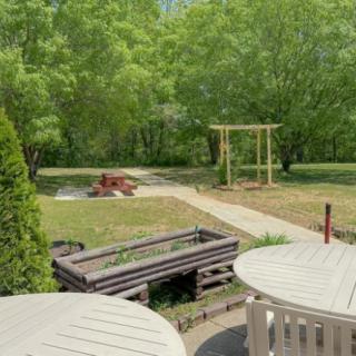 A peaceful garden patio area with tables, surrounded by lush greenery.
