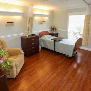 A clean and well-lit hospital room with a patient bed and comfortable seating.