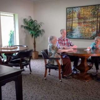 A group of people sitting and talking at a table in a cozy room.