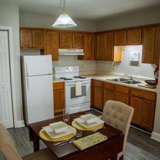 A cozy kitchen and dining area with wooden cabinets and a complete set of appliances.