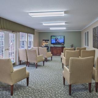 A cozy living room with multiple chairs facing a television.