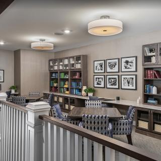 A modern library interior with bookshelves, comfortable seating, and framed artwork on the walls.