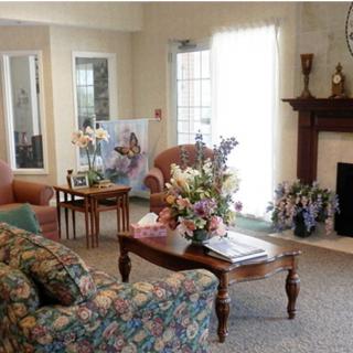 A cozy living room featuring floral decor with a sofa, coffee table, and fireplace.