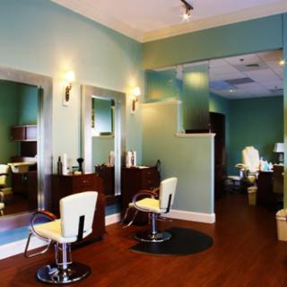 A modern hair salon interior with stylish seating and large mirrors.