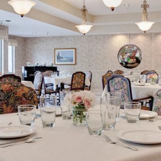 An elegantly set dining room with a formal table arrangement and ornate decor.