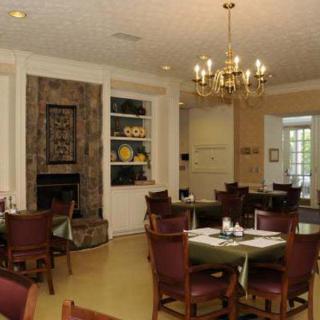 Elegant dining room with a chandelier and fireplace.