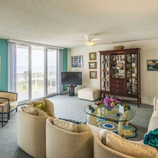 A spacious and elegantly decorated living room with modern furniture and large windows providing ample natural light.